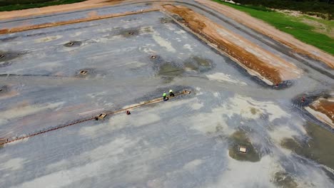two-workers-work-in-a-trench-where-a-concrete-pad-will-be-poured