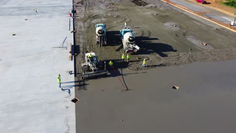 A-screed-machine-smooths-concrete-while-a-supervisor-observes