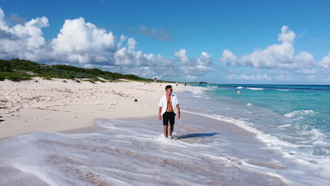 Junger-Sportlicher-Brauner-Mann-Mit-Weißem-Strandhemd,-Das-Auf-Sandiger-Tropischer-Insel-In-Cozumel-Mexiko-Geht