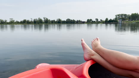Person-Relaxing-On-A-Plastic-Dinghy-Boat-Floating-Over-Peaceful-Lake