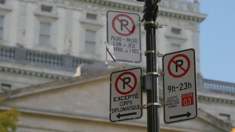 No-Parking-Signpost-And-Notice-In-French-Language-Along-The-Street-In-Montreal,-Quebec,-Canada