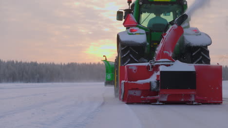Snow-blower-clearing-white-powder-snowdrift-from-Norbotten-Sweden-ice-track-at-sunrise