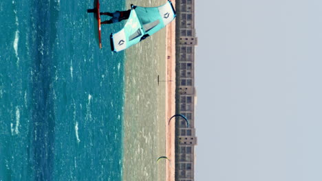 Video-Vertical,-Windsurfista-Deslizándose-En-El-Agua-Turquesa,-Windsurf,-Hurghada,-Egipto,-60-Fps