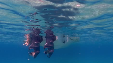 Slowmotion-Unterwasserszene-Menschlicher-Beine-Und-Füße-Im-Meerwasser-Unter-Der-Oberfläche,-Die-Aus-Der-Motorbootleiter-Herausragt