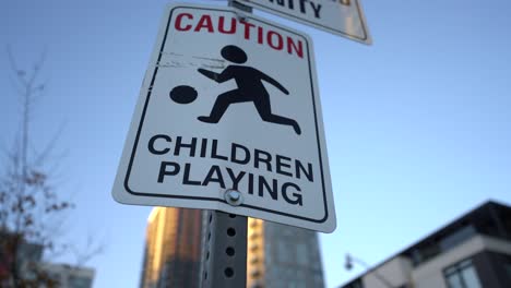 Close-up-pan-of-Caution,-Children-Playing-sign-near-park-in-neighbourhood