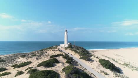 Aerial-view-over-the-dunes-and-over-the-Trafalgar-lighthouse-in-Cadiz,-Spain