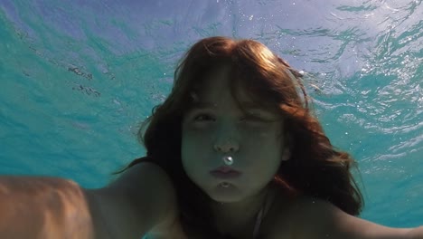 Unterwasser-Selfie-Eines-Schönen-Süßen-Kleinen-Rothaarigen-Mädchens,-Das-Den-Atem-Anhält,-Während-Es-In-Transparentem-Meerwasser-Schwimmt