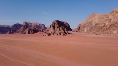 Vista-Aérea-De-Un-Automóvil-Conduciendo-Por-El-Asombroso-Desierto-De-Wadi-Rum-En-Jordania