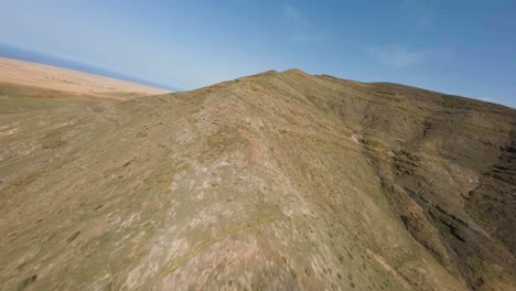 fuerteventura-FPV-dry-rocky-vulcan-mountain-rdige-climb-blue-sky