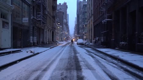Man-walks-into-the-vanishing-point-on-Soho-street-on-snowy-morning-in-Manhattan,-New-York
