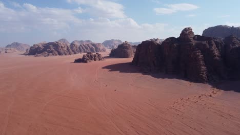 Tolle-Aussicht-Auf-Zwei-Autos,-Die-Durch-Die-Wadi-Rum-Wüste-Mit-Felsbergen-In-Jordanien-Fahren