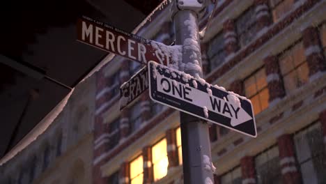 Street-signs-at-the-intersection-of-Mercer-and-Grand-streets-during-snowy-morning-before-sunrise
