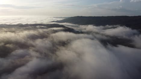 Vista-Aérea-De-Una-Montaña-Con-Niebla-O-Nubes-Blancas-Por-La-Mañana