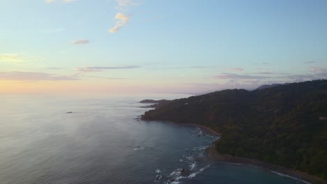 Drone-Flying-over-uninhabited-calm-waves-coastline-beautiful-morning-sunrise