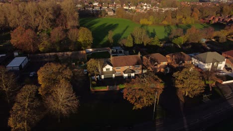 Englische-Dorfhäuser-Auf-Dem-Land,-Umgeben-Von-Herbstbäumen-Zur-Goldenen-Stunde-Luftbild
