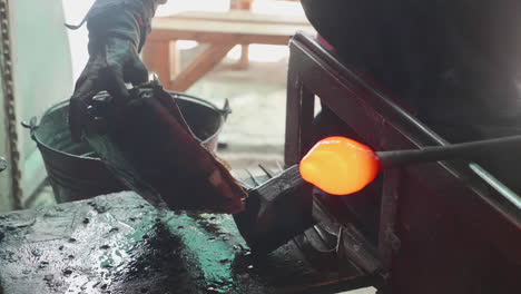 A-man-molding-hot-glass-while-seated
