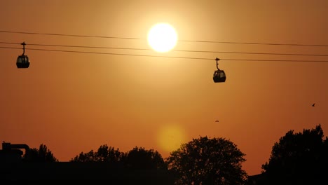 Gondola-Cableway-passing-by-during-Sunset-with-orange-red-evening-Sky-and-Sun-in-Constanta-Romania