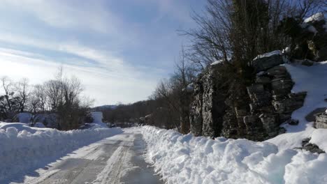 Traveling-by-car-through-snowy-mountain-road-in-Zagori,-Greece