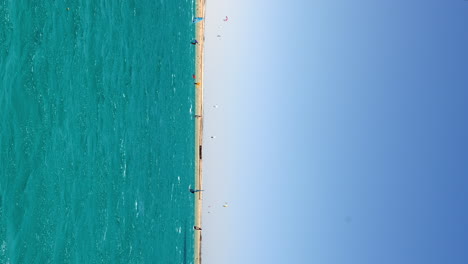 Vertical-Video-Zoom-in-on-Windsurfers,-Paradise-Beach,-Divine-Waters-of-Hurghada-Egypt,-Windsurfing-Shot-in-60-Fps