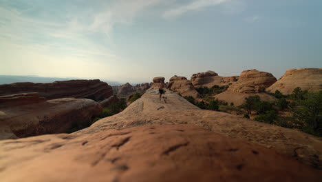 Niedriger-Winkel-Des-Mannes,-Der-Auf-Felsen-In-Der-Wüste-Von-Utah-Bei-Sonnenuntergang-Für-Gesundheit-Und-Wellness-Läuft