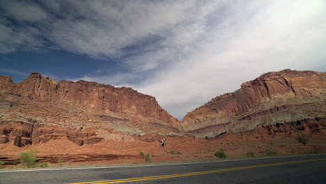 Woman-hiking-along-highway-in-desert-in-Utah