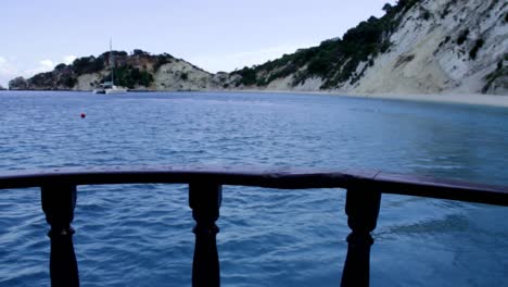 Boat-sailing-away-from-Gidaki-beach-on-the-coast-of-Ithaca-island-in-Greece