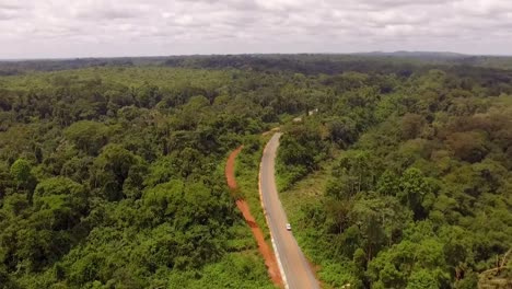 Aerial-drone-view-over-a-road,-in-the-Jungle,-on-a-sunny-day,-in-Nanga-Eboko,-Haute-Sanaga,-Southern-Cameroon
