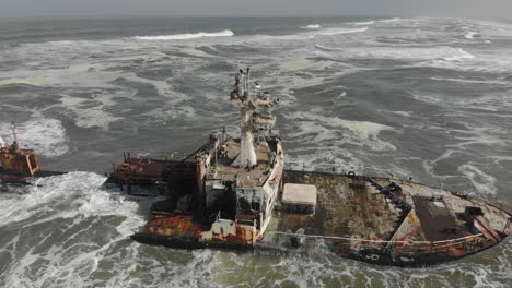 Aerial-rotation-around-remains-of-shipwreck---crashing-waves