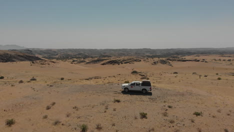 Aerial-flight-over-stationary-vehicle-alone-in-desert