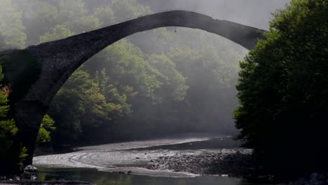 Nebel-Rund-Um-Eine-Gewölbte-Steinbrücke-Im-Fluss-Aoos-In-Griechenland