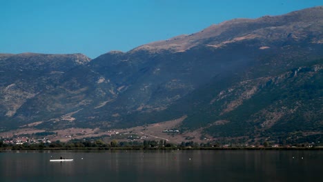 A-person-is-rowing-in-front-of-the-mountains-of-the-lake-of-Ioannina-in-Greece
