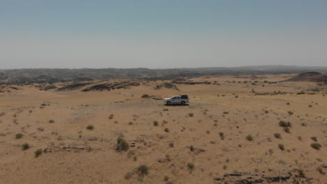 Aerial-rotating-shot-of-vehicle-in-the-desert
