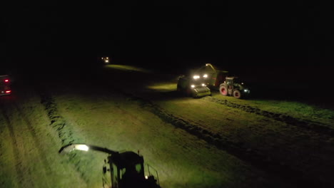 Aerial-views-over-farming-vehicles-working-at-night-by-spotlight