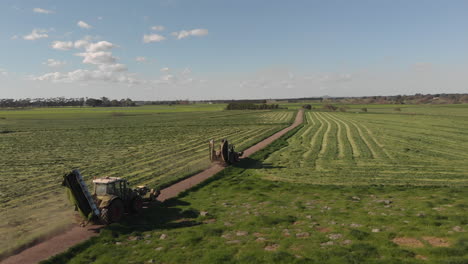 Aerial-footage-following-two-tractor-mowers-from-the-side
