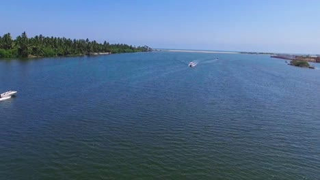 Drone-shot-flying-across-backwater-canal-with-a-speed-boat-crossing-frame