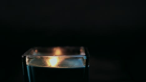 lighting-a-candle-against-a-black-backdrop