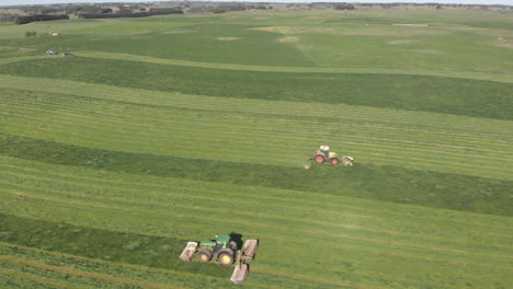 Aerial-panning-rotation-around-two-tractors-driving-either-direction-in-paddock