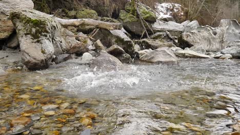 Gran-Roca-Arrojada-Al-Agua-En-Cámara-Lenta-Con-Fondo-Verde-Rocoso-Natural-Tranquilo