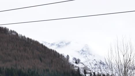 static-4k-video-of-two-chair-lifts-passing-by-with-mountain-background-in-a-ski-resort