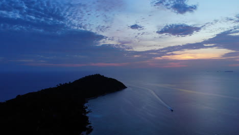 Luftaufnahme-Des-Meeres-Und-Der-Berge,-Mit-Einem-Boot-Und-Dem-Sonnenuntergang