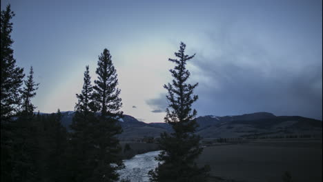 Timelapse-Countryside-Mountains-with-Sunset-to-Night-Stars,-then-a-Snow-Storm-Approaches-from-Upriver