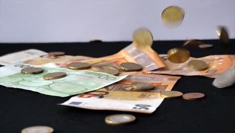 Euro-coins-dropping-onto-notes-4k