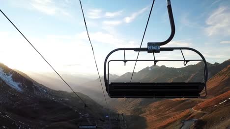 beautiful-drone-view-of-a-ski-lift-looking-at-a-sunset-on-a-mountain