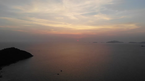 Luftaufnahme-Des-Sonnenuntergangs-über-Dem-Meer-Mit-Booten-Und-Bergen-Im-Hintergrund