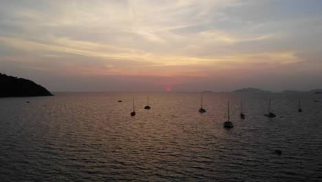Flug-über-Das-Meer-Und-Boot-Mit-Sonnenuntergang-Und-Bergen-Im-Hintergrund