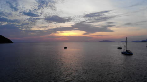 Luftaufnahme-Des-Ozeans-Mit-Einem-Boot-Und-Einem-Farbenfrohen-Sonnenuntergang
