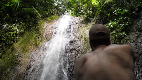 Photographer-Taking-Photos-up-Tropical-Jungle-Waterfall-From-Behind-Slow-Motion