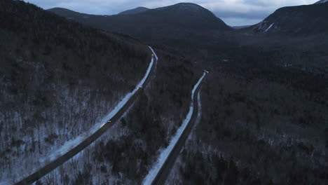 drone-video-at-dusk-in-the-mountains-with-cars-driving-toward-the-drone