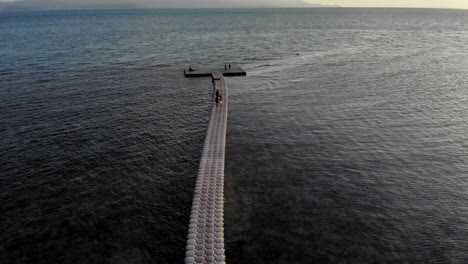 Drone-shot-of-a-floating-pier-with-people-walking-on-it