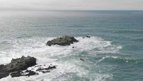 Waves-crashing-on-rocks-in-the-ocean-drone-shot-